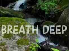 Mossy rocks and waterfall with Breathe Deep text